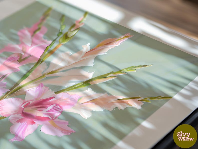 May include: A close-up of a framed print of pink and white gladioli flowers with green stems. The flowers are arranged in a bouquet and are set against a light green background.