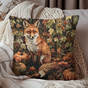May include: Decorative throw pillow featuring a detailed illustration of a fox in a forest setting. The pillow showcases a vibrant autumn scene with pumpkins and colorful leaves. The fox has orange and white fur.