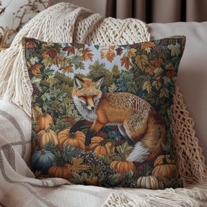 May include: A throw pillow with a tapestry design featuring a red fox walking through a forest scene with fall leaves and pumpkins.