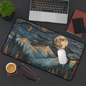 May include: A blue and gold mountain scene with a full moon and stars. The scene is printed on a black mouse pad.