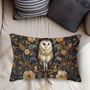 May include: A rectangular throw pillow with a dark blue background featuring a white barn owl perched on a branch with gold and brown floral accents.