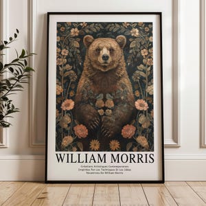 May include: A framed art print featuring a brown bear surrounded by flowers in shades of peach and green against a dark background. The print includes the text "WILLIAM MORRIS" and additional French text at the bottom.