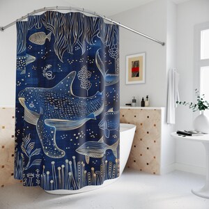 May include: A blue shower curtain with a white whale and other fish swimming in a starry night sky. The whale is outlined in gold and has a detailed pattern of white dots. The background is a dark blue with white stars and gold seaweed.