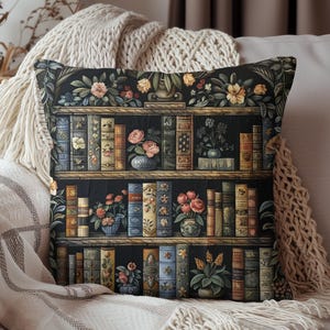 May include: A black and white throw pillow with a vintage illustration of a bookshelf filled with books and flowers. The bookshelf has five shelves and is decorated with a floral motif.