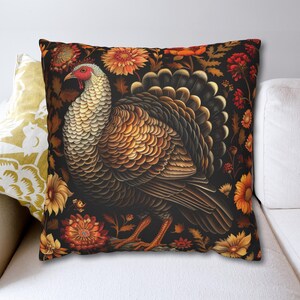 May include: A throw pillow with a dark background featuring a detailed illustration of a brown and white turkey with a red wattle. The turkey is surrounded by colorful flowers and leaves.