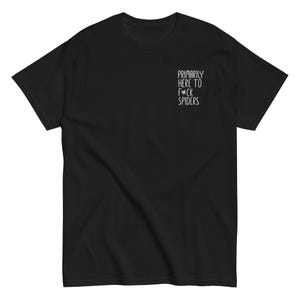 Peut inclure: T-shirt noir avec l'inscription blanche "Primarily Here To F*ck Spiders" sur la poitrine. Le t-shirt a des manches courtes et un col rond.