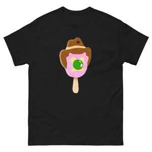 May include: A black t-shirt with a pink and brown popsicle wearing a brown cowboy hat. The popsicle has a green circle on its face.