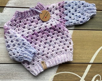 Crochet baby sweater in purple.