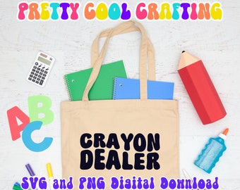 Può includere: Una borsa tote in tela beige con il testo nero CRAYON DEALER stampato sul davanti. La borsa contiene un quaderno verde e uno blu. Attorno alla borsa ci sono una calcolatrice, una grande matita rossa, colla, forbici, pennarelli e le lettere A, B e C.