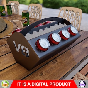 Puede incluir: Un enfriador de latas de metal con asa y un diseño recortado que dice "V83". El enfriador contiene varias latas de refresco y hielo. El enfriador está sobre una mesa de madera.