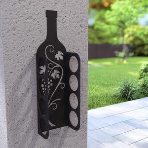 Puede incluir: Estante para vino de metal negro con una silueta de botella y un dise&ntilde;o de vid. El estante tiene seis ranuras para guardar botellas de vino.