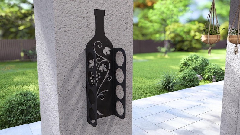Puede incluir: Estante para vino de metal negro con una silueta de botella y un dise&ntilde;o de vid. El estante tiene seis ranuras para guardar botellas de vino.