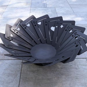 May include: A decorative, dark gray bowl crafted from playing card shapes. The bowl features a circular base and the cards are arranged in a fan-like pattern, showcasing the suits of hearts, diamonds, clubs, and spades.