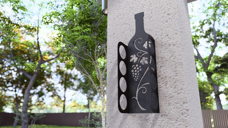 Puede incluir: Estante para botellas de vino de metal negro con dise&ntilde;o de vid. El estante tiene capacidad para seis botellas de vino y se monta en la pared.