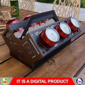 May include: A metal six-pack holder with a black handle and a design of a car engine. The holder is filled with six red aluminum cans.