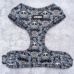 May include: A black and white dog harness with a spooky bat and spiderweb pattern. The harness has a blue background and the text "Pup Rock Pet Accessories" is printed on the front.