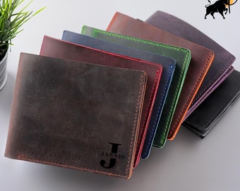 May include: A stack of six leather wallets in various colors, including brown, red, blue, green, and purple. The top wallet has the name "Jannis" and the initial "J" embossed on it.