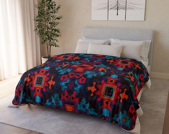May include: A colorful blanket with a geometric pattern in shades of red, orange, blue, and purple. The blanket is draped over a bed with white bedding. The overall design has a Southwestern or tribal aesthetic.