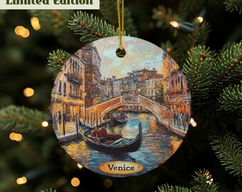 May include: Round Christmas ornament featuring a painting of Venice, Italy, with a gondola on the canal and a bridge in the background. The ornament has a gold string for hanging and the text "Venice" and "Limited Edition".