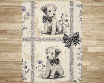 May include: A rectangular cream-colored mat featuring a vintage-style illustration of two puppies wearing checkered bow ties. The mat has a floral and checkered border design with purple flowers and a large checkered bow.