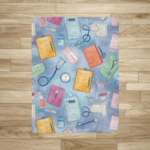 Könnte beinhalten: Ein medizinisch thematisiertes Muster im Aquarellstil mit Klemmbrettern, Stethoskopen, Medikamentenflaschen und medizinischen Diagrammen. Das Design umfasst orange, rosa und blaue Elemente auf hellblauem Hintergrund. Eine Uhr ist ebenfalls sichtbar.