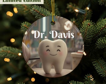 May include: A round, clear glass ornament with a gold string for hanging. The ornament features a smiling cartoon tooth with pink cheeks and the text "Dr. Davis" in white. The words "Limited Edition" are in a green box at the top.