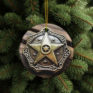 May include: A round, gold-colored Christmas ornament with a five-pointed star design. The star has a smaller star in the center and is surrounded by smaller stars. The ornament is hanging from a green Christmas tree.