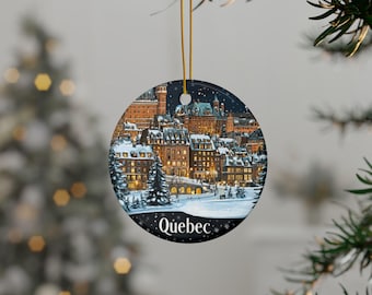 May include: A round ceramic ornament featuring a snowy winter scene of the cityscape of Quebec City, Canada. The ornament is decorated with a dark blue background and white snow, with the city's buildings and a bridge visible in the distance. The text "Quebec" is printed in white at the bottom of the ornament.