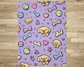 May include: A rectangular, lavender-colored blanket featuring a repeating pattern of cartoon puppies, bones, hearts, paw prints, and tennis balls. The puppies are yellow with black eyes and noses. The bones are pink and blue.