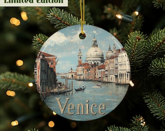 May include: Round Christmas ornament featuring a scenic view of Venice, Italy, with the word "Venice" in a vintage font. The ornament has a blue sky and water background, with buildings and boats. The text "Limited Edition" is in the upper left corner.