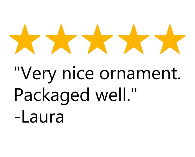 May include: Five gold stars above a customer review. The review reads: "Very nice ornament. Packaged well." Below the review is the name "-Laura".