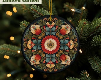 May include: A round, black Christmas ornament with a floral design in red, orange, teal, and white. The ornament is hanging from a gold string against a backdrop of a Christmas tree. The text "Limited Edition" is at the top.