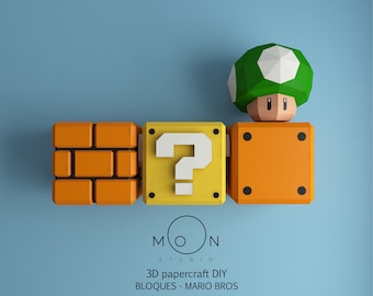 Könnte beinhalten: Ein 3D-Papierbastelset von Mario Bros.-Blöcken, bestehend aus einem Fragezeichenblock, einem Ziegelblock und einem Pilz. Die Blöcke sind orange und gelb, der Pilz ist grün.