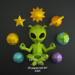 Puede incluir: Un alienígena verde de papel en posición de meditación, rodeado de estrellas amarillas, sol, luna, planeta y otros cuerpos celestes. El texto "MOON STUDIO" y "3D papercraft DIY ALIEN" son visibles.