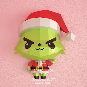Könnte beinhalten: Ein grünes und rotes Papiermodell des Grinch, der einen Weihnachtsmann-Hut trägt. Der Grinch hat einen schelmischen Ausdruck mit großen Augen und einem breiten Lächeln. Der Text "3D papercraft DIY KAWAII GRINCH" ist unter dem Modell gedruckt.