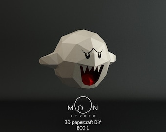 May include: A white papercraft model of a ghost with a red mouth and black eyes. The model is labeled "3D papercraft DIY BOO 1" and "MOON STUDIO".