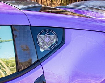 Puede incluir: Un coche morado con un alerón negro y ruedas blancas. El coche tiene una pegatina en la ventana trasera con un diseño de pentagrama.