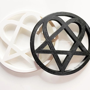 May include: Two decorative wall hangings in the shape of a heart with a star inside. One is white and the other is black.