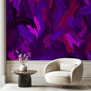 May include: A white armchair with a rounded back and a purple abstract painting on the wall behind it.