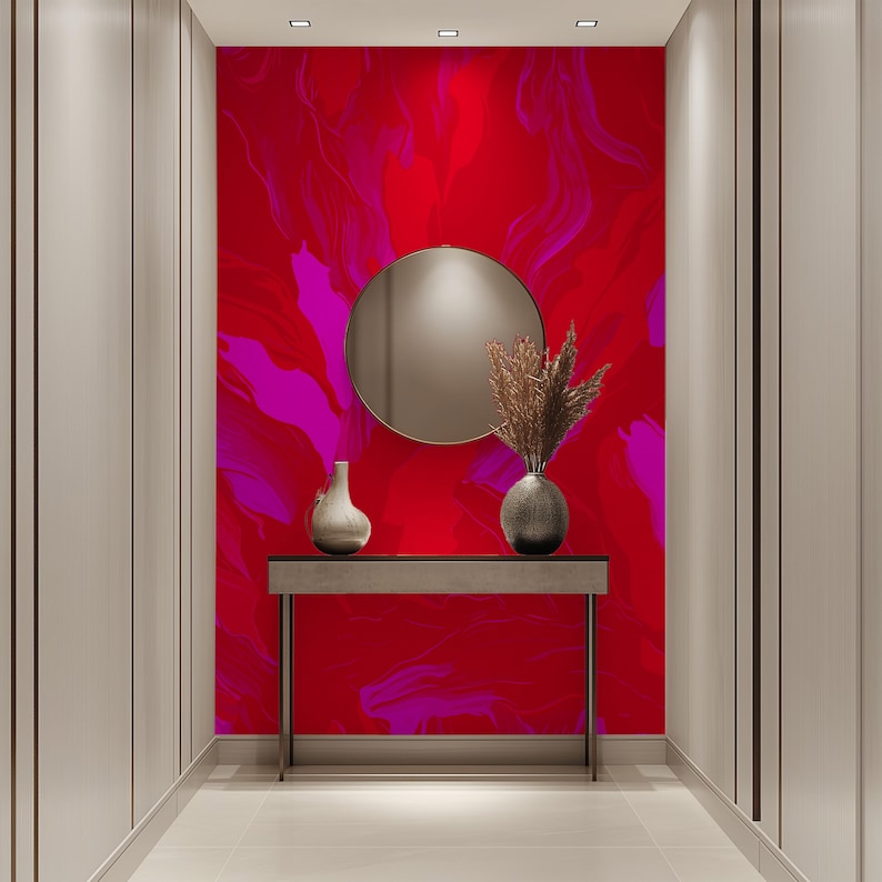 May include: A hallway with a red and pink abstract wall mural, a round mirror, a console table, and two vases with dried flowers.