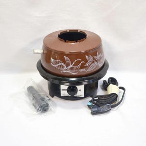 Può includere: Pentola per fonduta elettrica marrone e nera con design a foglie bianche e la parola "Pepper". La base ha un quadrante di controllo e il testo "Sears Electric Fondue". Include un cavo nero e un oggetto di plastica nera.