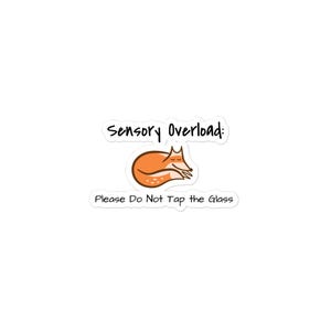 May include: A white sticker with the text "Sensory Overload:" above a cartoon fox illustration. Below the fox, the text reads "Please Do Not Tap the Glass."