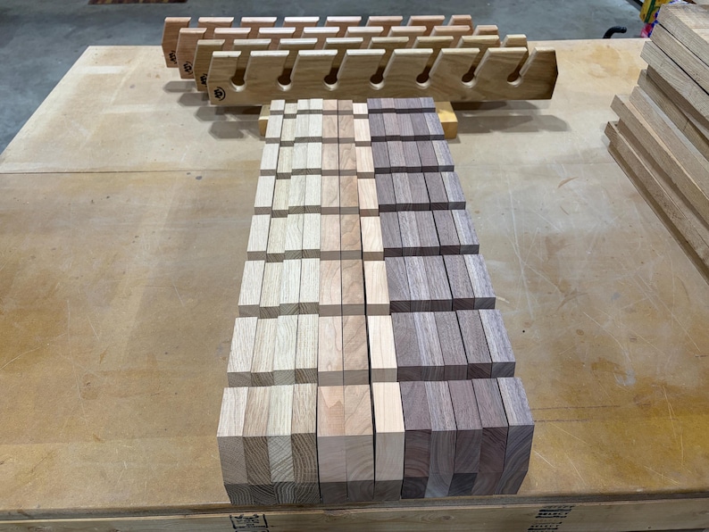 Puede incluir: Una colecci&oacute;n de estantes de madera con ranuras en &aacute;ngulo para almacenamiento. Los estantes est&aacute;n hechos de madera clara y madera de tono nogal m&aacute;s oscuro, dispuestos en filas paralelas con un patr&oacute;n de cuadr&iacute;cula de segmentos verticales y horizontales.