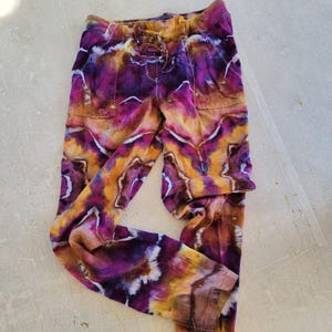 May include: Purple, orange and brown tie-dye trousers with a drawstring waist.