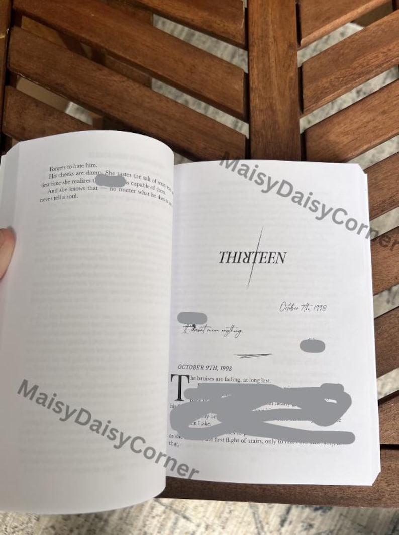 Puede incluir: Libro abierto con la palabra "THIRTEEN" en gran fuente. Las p&aacute;ginas muestran texto y fechas, incluyendo "October 7th, 1998" y "October 9th, 1998". El libro est&aacute; sobre una superficie de madera.