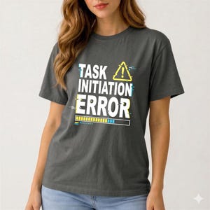 Könnte beinhalten: Dunkelgraues T-Shirt mit dem Text "TASK INITIATION ERROR" in Weiß, Gelb und Blau. Das Design beinhaltet ein gelbes Warnsymbol und eine Fortschrittsbalken-Grafik. Das Shirt ist ein lässiger Stil mit kurzen Ärmeln.