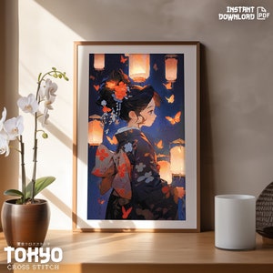 May include: A framed illustration of a woman in a traditional Japanese kimono standing in front of a blue background with glowing lanterns and butterflies. The woman has dark hair and is wearing a red flower in her hair. The text "TOKYO CROSS STITCH" is at the bottom of the image.