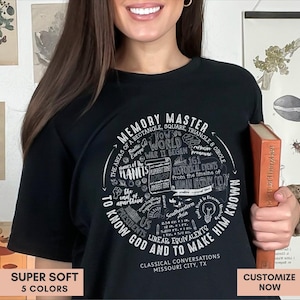 May include: A black short-sleeve t-shirt featuring a circular white graphic design filled with educational text including Memory Master, historical events, planet names, and mathematical formulas, with Classical Conversations Missouri City, TX at the base.