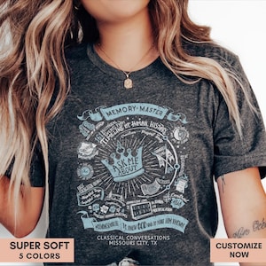 May include: Dark gray t-shirt with a light blue graphic design featuring the text "Ask Me About" above a crown. The design includes the words "Memory Master" and "Classical Conversations Missouri City, TX".