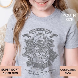May include: A heather gray short-sleeve t-shirt featuring a dark gray graphic print with the text "MEMORY MASTER CYCLE 1 2024-2025", "GOD TO MAKE HIM KNOWN", "CC HOMESCHOOL LIFE", and "CLASSICAL CONVERSATIONS MISSOURI CITY, TX" surrounded by various book illustrations.